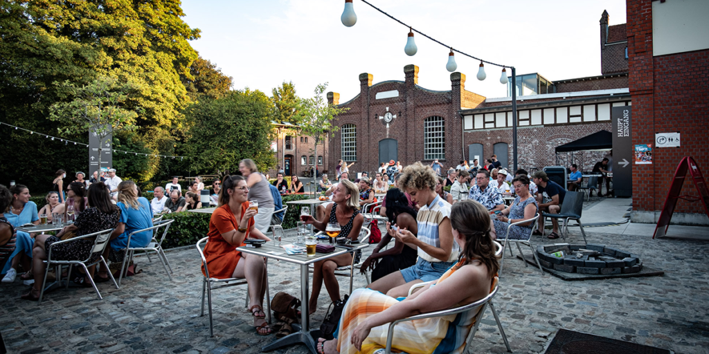 Momentaufnahme der Besucher beim FEIERabend. Vier junge Frauen sitzen an einem Bistro Tisch
