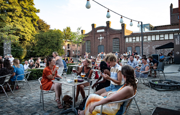 Momentaufnahme der Besucher beim FEIERabend. Vier junge Frauen sitzen an einem Bistro Tisch.