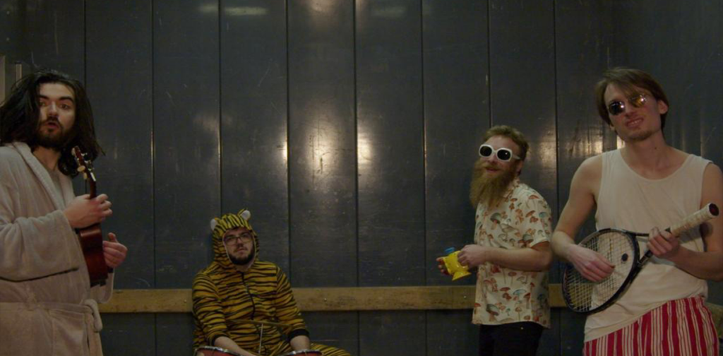 Bandportrait. Die Künstler sind verkleidet und tragen Sonnenbrille,Tierkostüm, Bademantel.....
