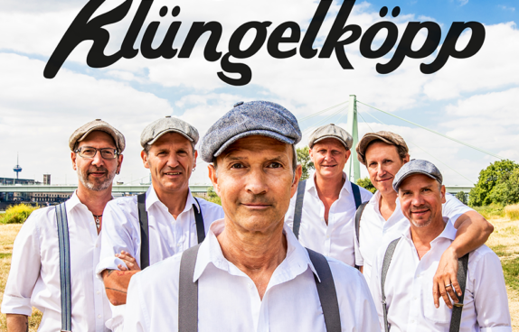 Bandfoto der Gruppe Klüngelköpp. Alle Musiker tragen eine Kappe und weiße Hemden mit Hosenträger.