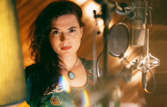 Portrait der Künstlerin, aufgenommen in einem Musikstudio. Rechts von ihr ein Studiomikrophon