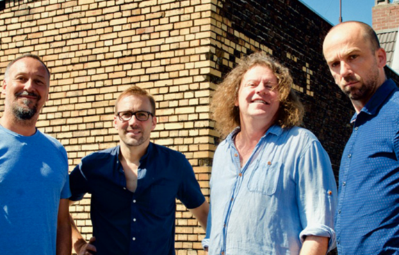 Bandfoto vor einer Mauer