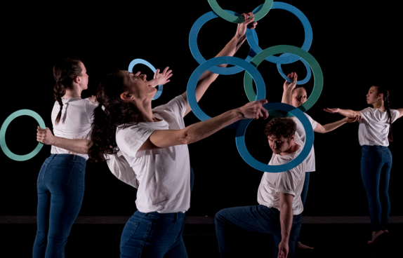Mehrere Tänzer der Compagnie Gandini Juggling jonglieren mit blauen Reifen