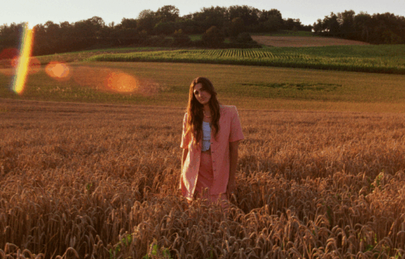 Foto von Musikerin Marla Moya auf einer Wiese bei Sonnenuntergang