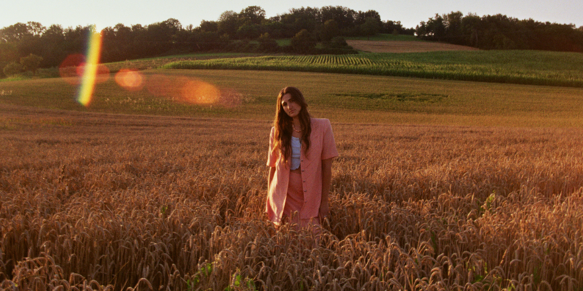 Foto von Musikerin Marla Moya auf einer Wiese bei Sonnenuntergang