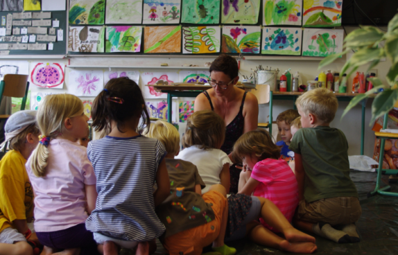 Bild einer Kindergruppe und einer Betreuerin, im Rahmen einer vorherigen Sommerwerkstatt.